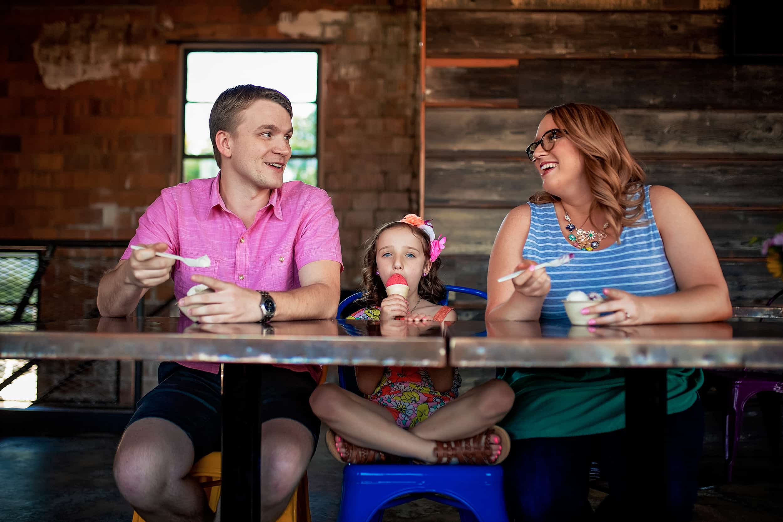 A family sits at a table eating ice cream.
