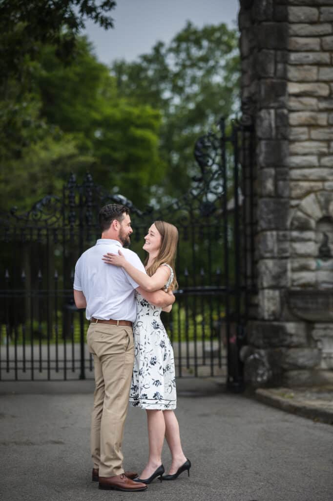 An engaged couple embracing in front of an iron gate during their Frankfort KY engagement photoshoot.