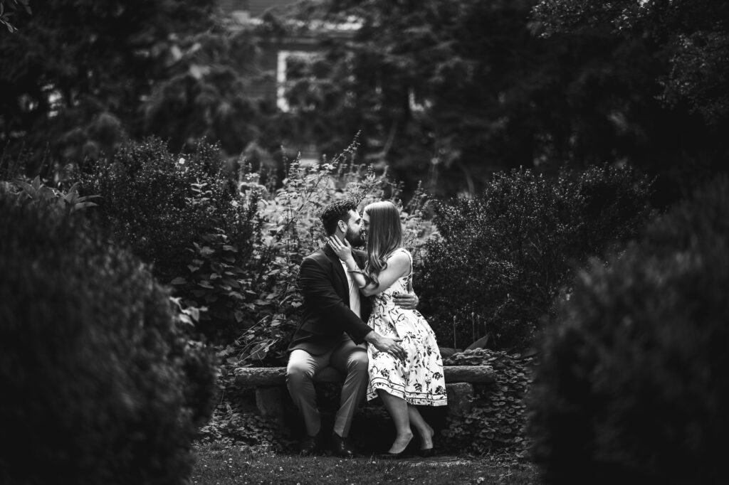 A couple kissing in a garden captured in black and white Frankfort KY engagement photos.
