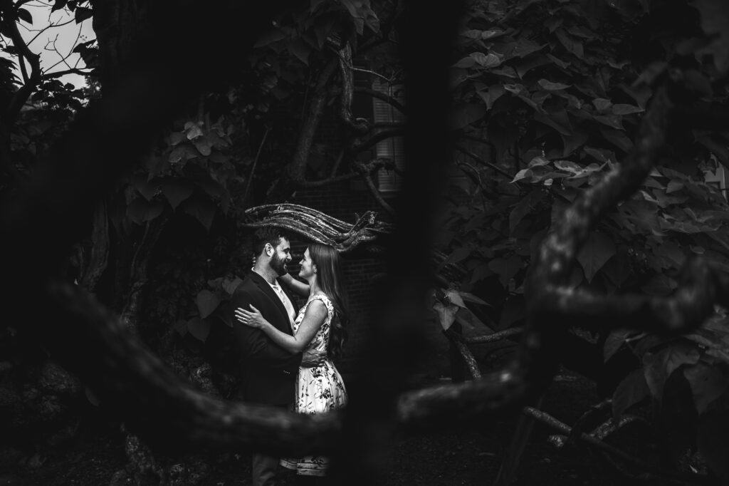 A black and white photo of a couple hugging in the woods during their Frankfort, KY engagement shoot.