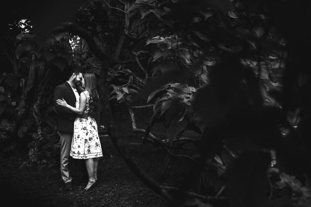 A couple kissing under a tree in Frankfort, KY captured in black and white for their engagement photos.