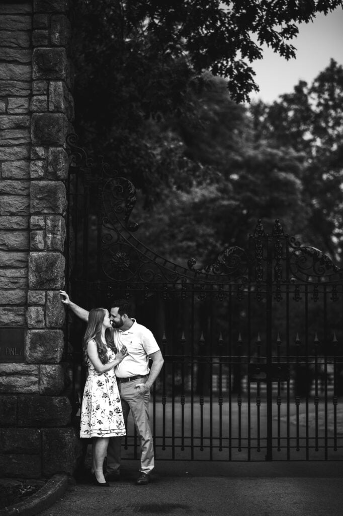 An engagement photo in Frankfort KY featuring a couple kissing in front of a gate.