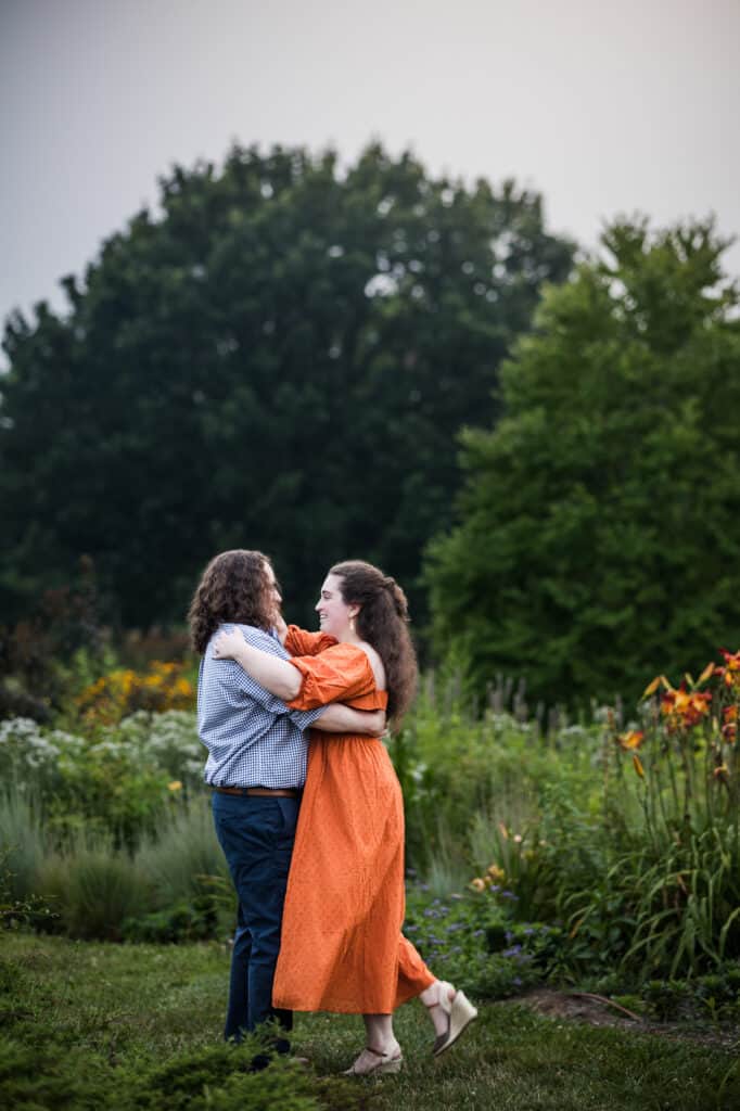 Two people embrace during their engagement session at the UK Arboretum.