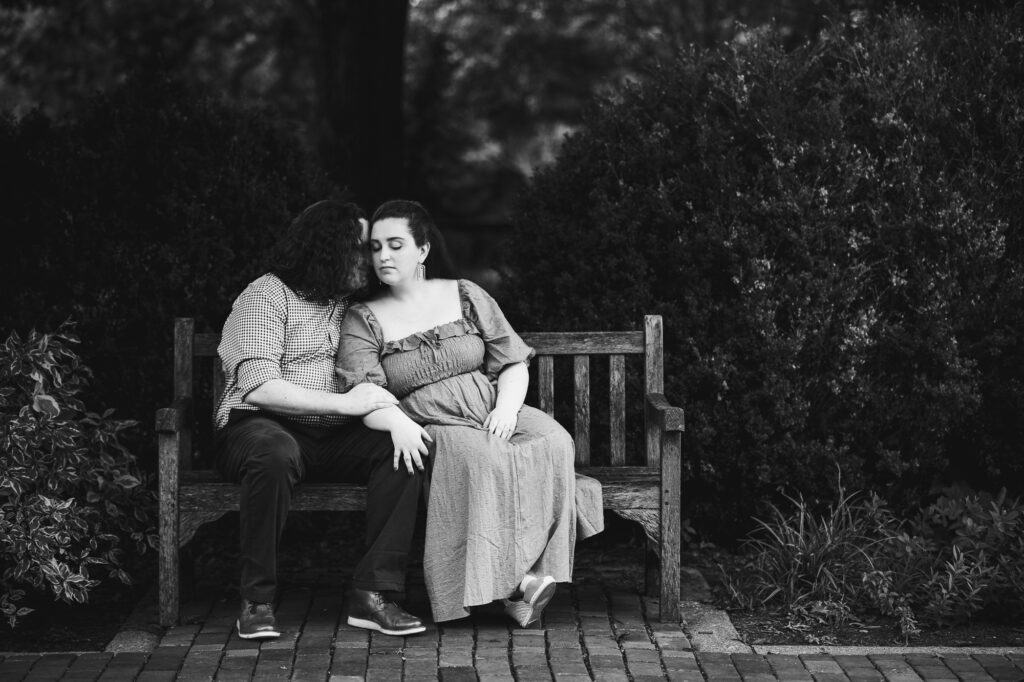 Engagement session photo of a couple sitting on a bench at UK Arboretum.