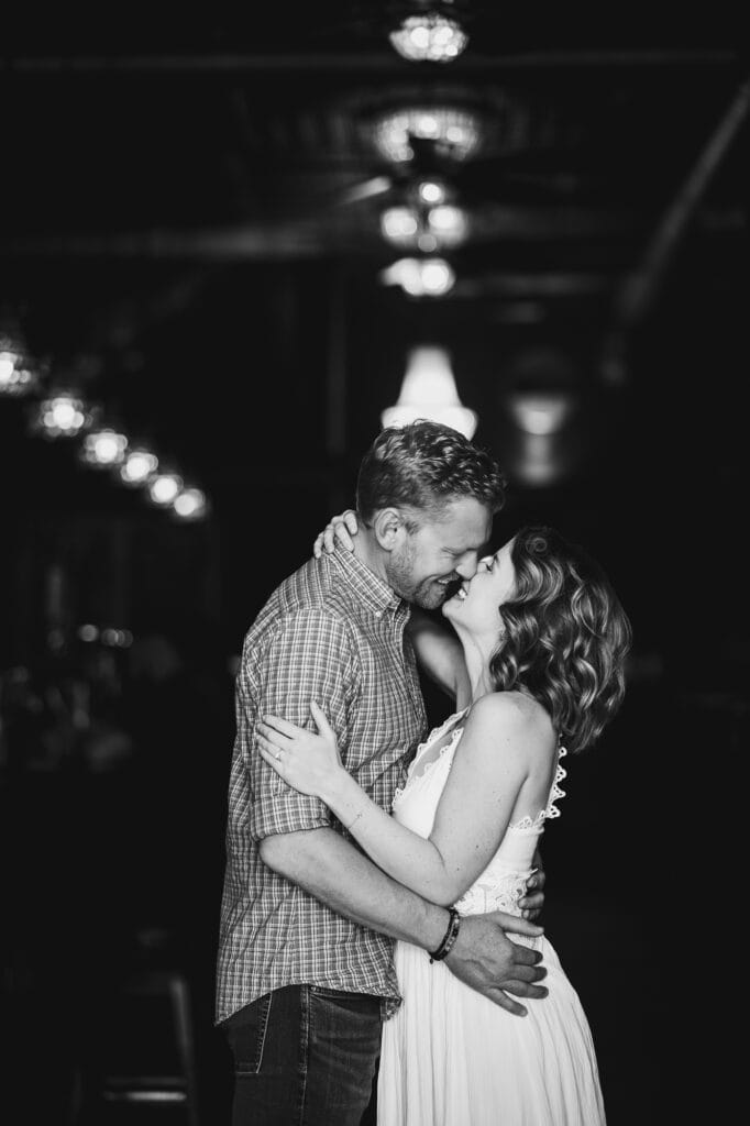 A monochrome photo captures an intimate kiss between a couple during their engagement session at Bourbon on Rye.