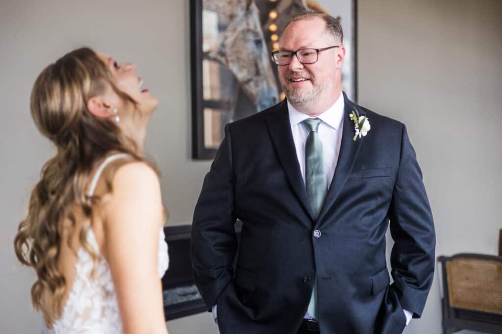 A Harper Hall groom and his bride share a joyful laugh while dressed in formal attire.