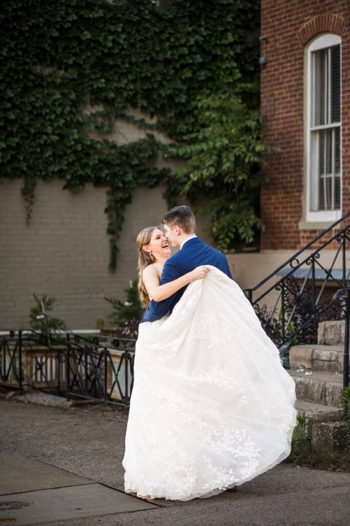 A Harper Hall wedding with the bride and groom hugging in front of a building.