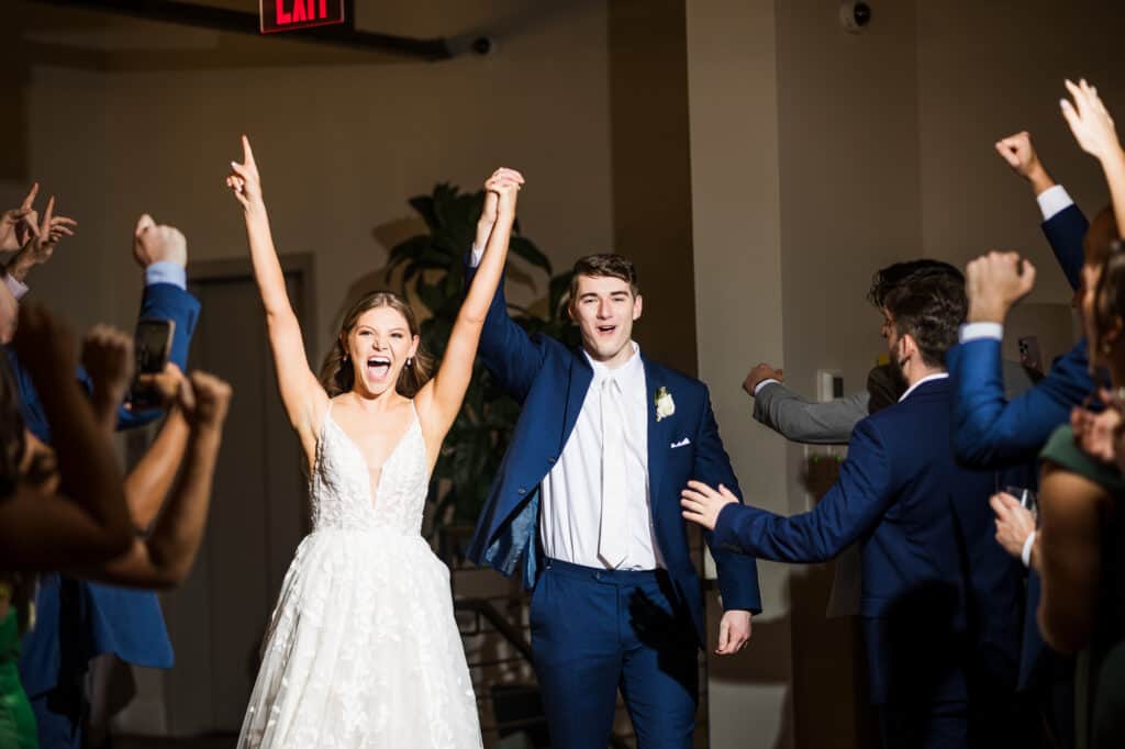 A Harper Hall wedding with the bride and groom raising their arms.