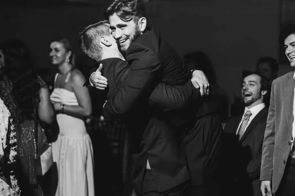 At the Harper Hall wedding, a man tenderly embraces another man while on the dance floor.
