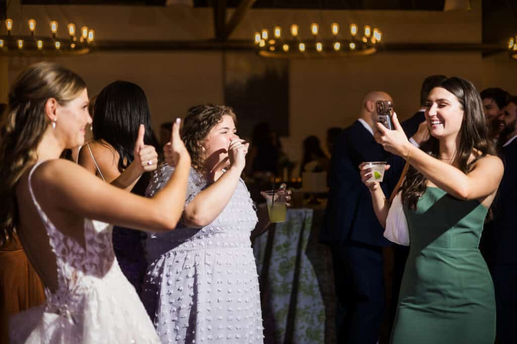 Brides and grooms are smiling and giving thumbs up at the Harper Hall wedding reception.