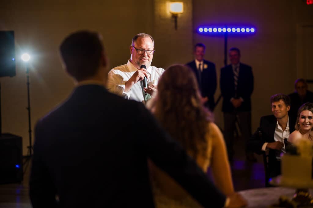 A man giving a speech at the Harper Hall wedding reception.