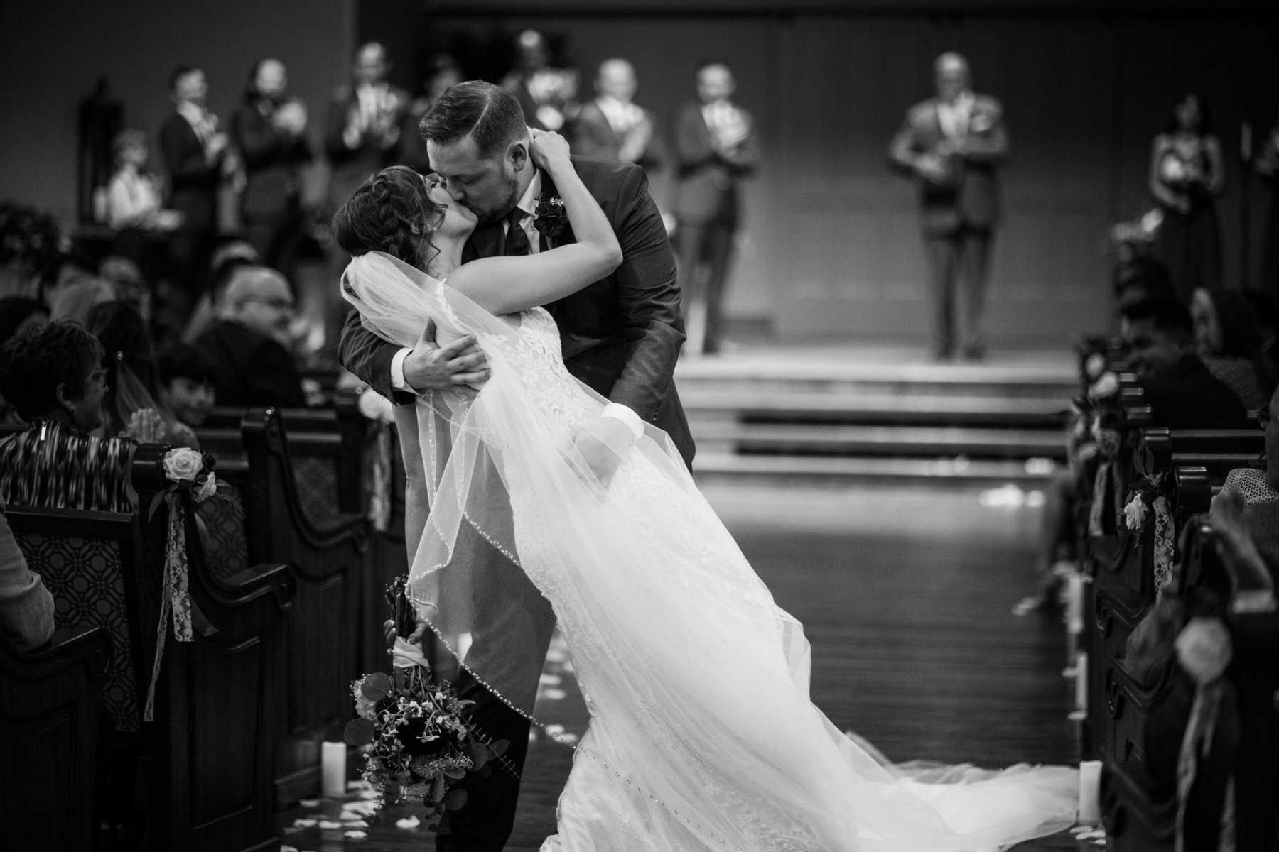A bride and groom kiss during their wedding ceremony.