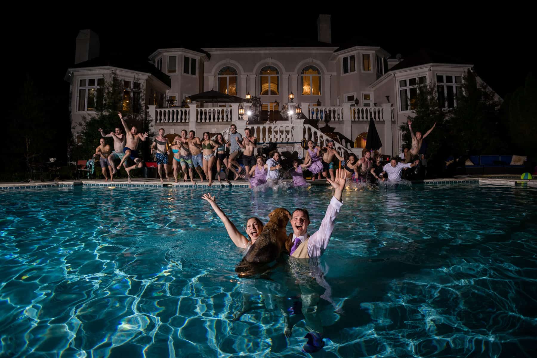 A group of people in a pool at night.