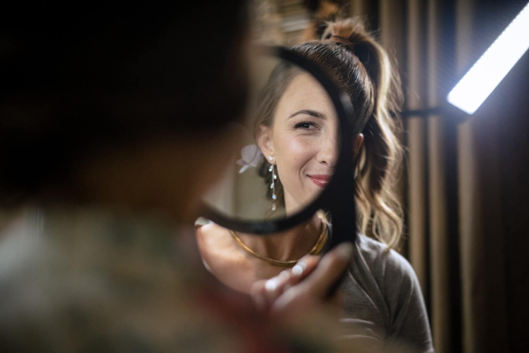 A woman looking at herself in a mirror.