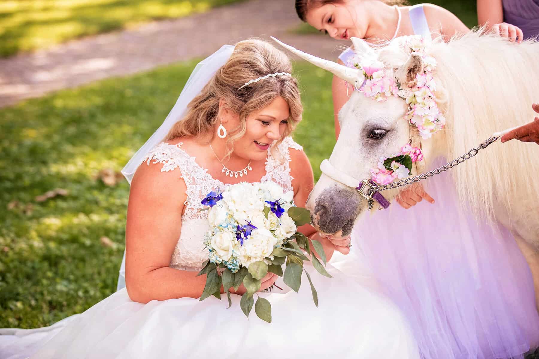 A bride is petting a white unicorn.