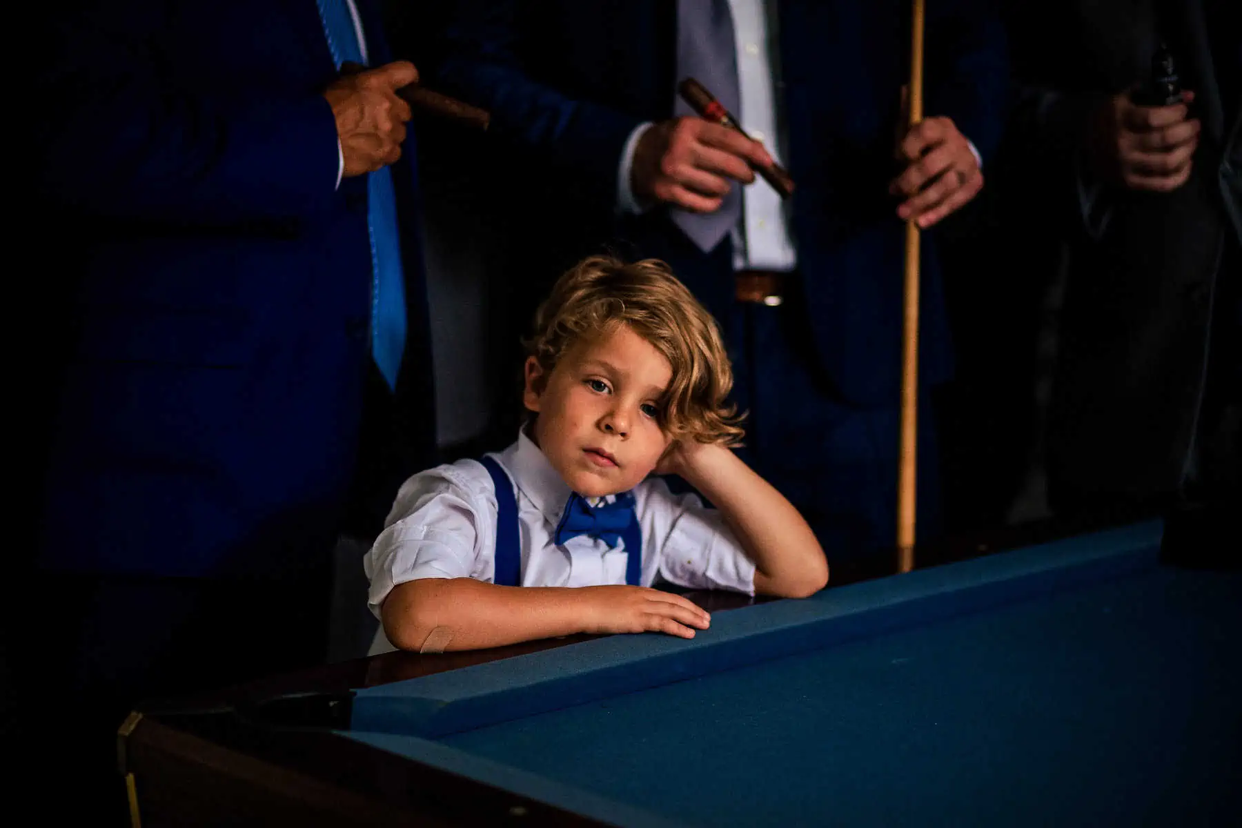 A young boy leaning over a pool table.