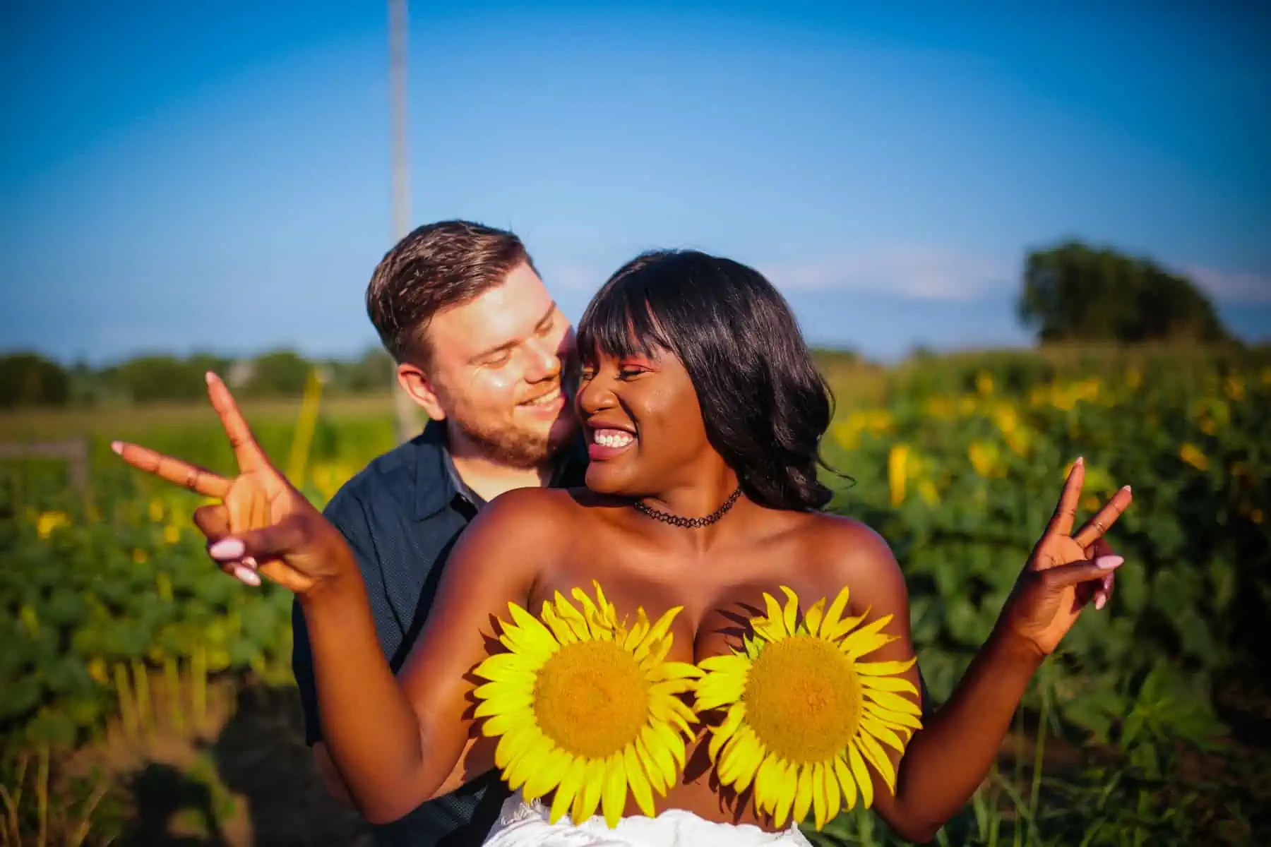 A couple posing in a sunflower field.