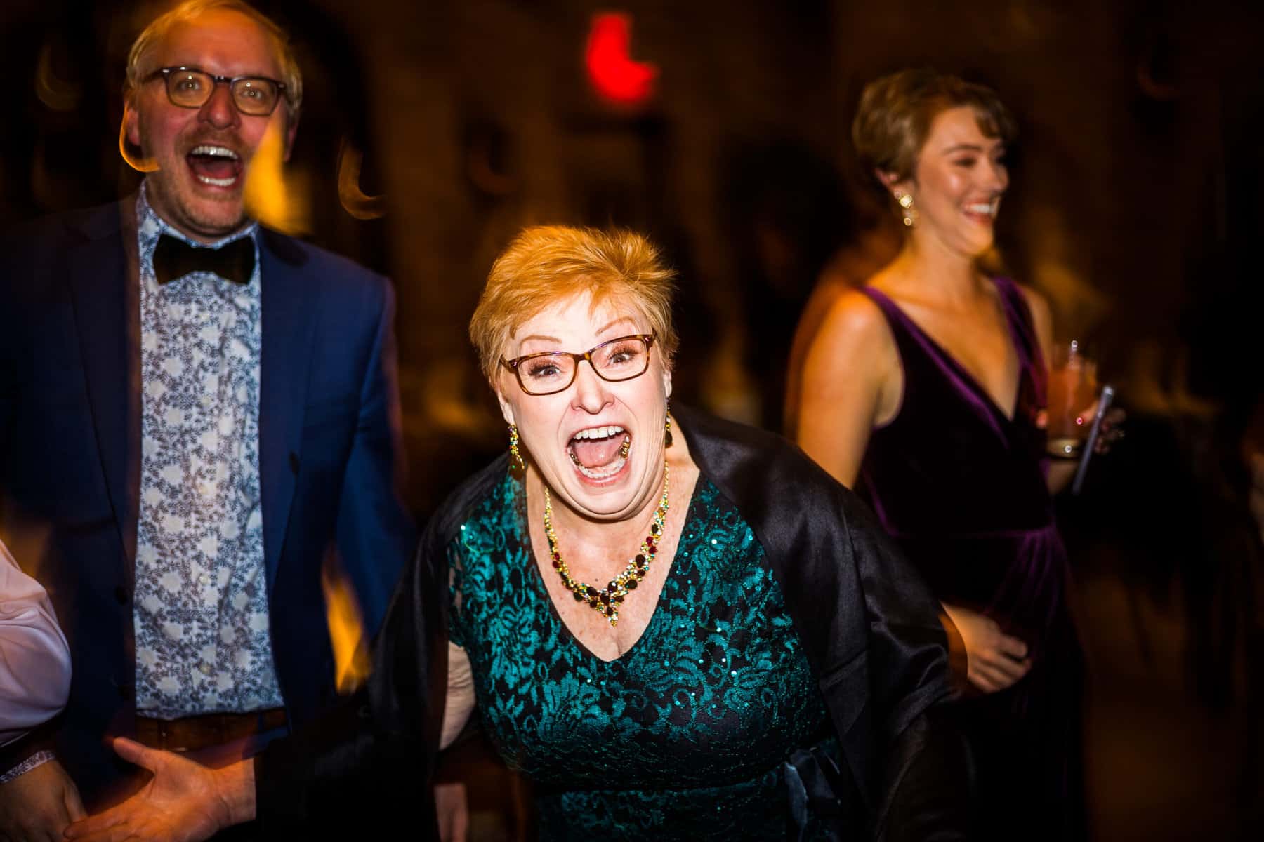 A woman is laughing at a wedding reception.