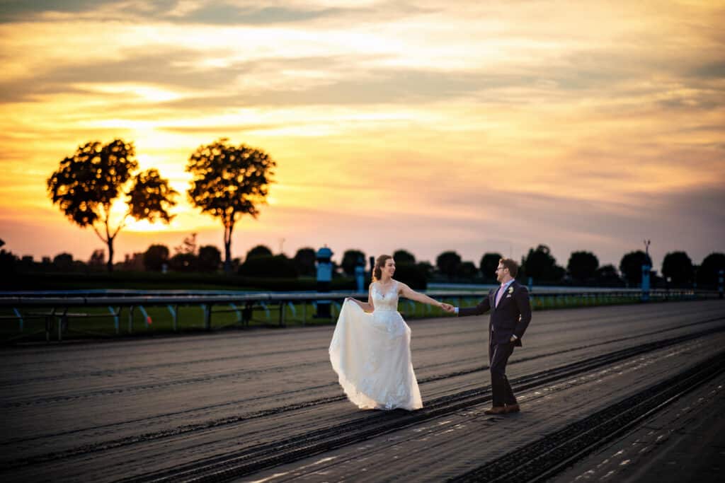 A Stunning Sunset Moment Captured By Lexington Ky Wedding Photographers, Featuring A Bride And Groom On A Track.