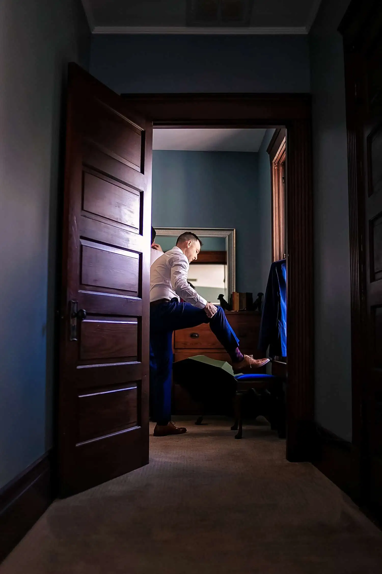 A man putting on his shoes in a room.