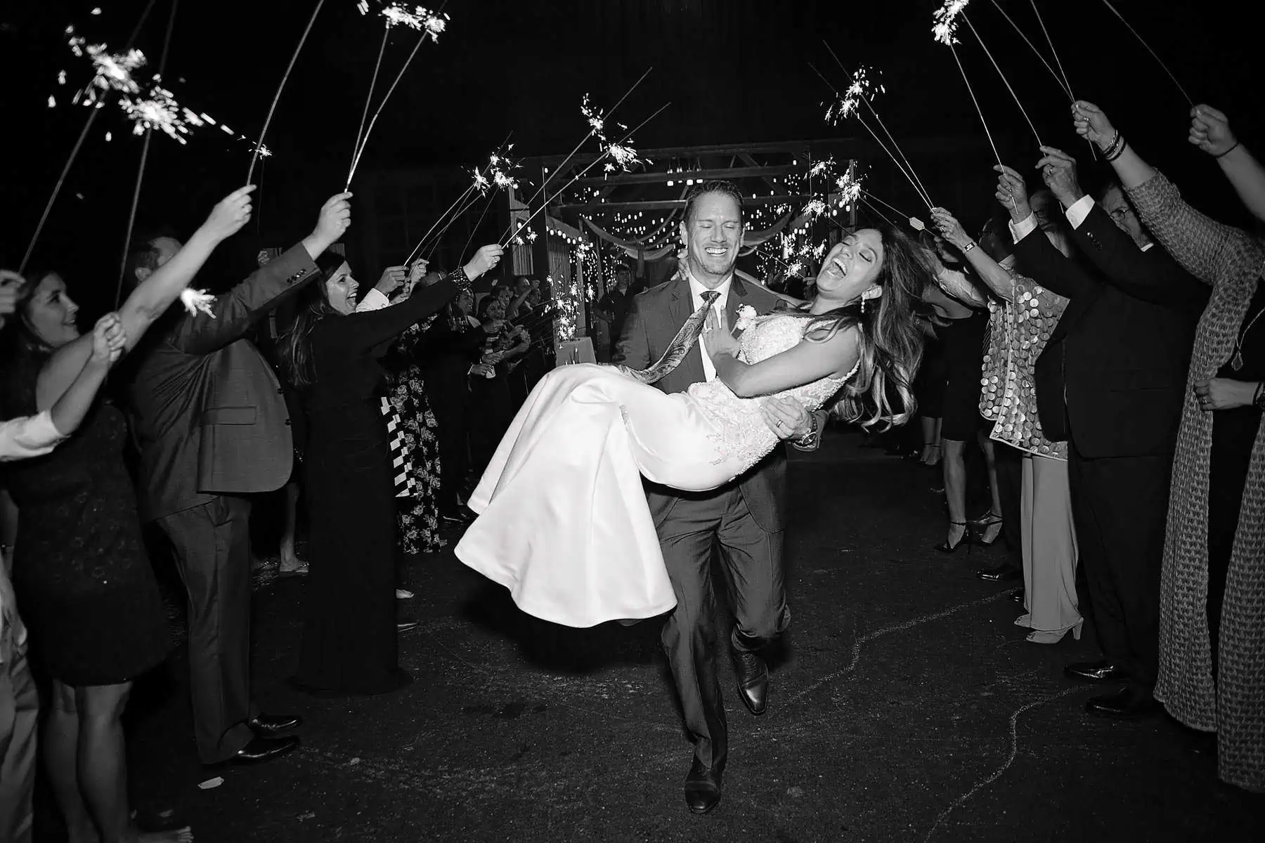 A bride and groom holding sparklers in the air.