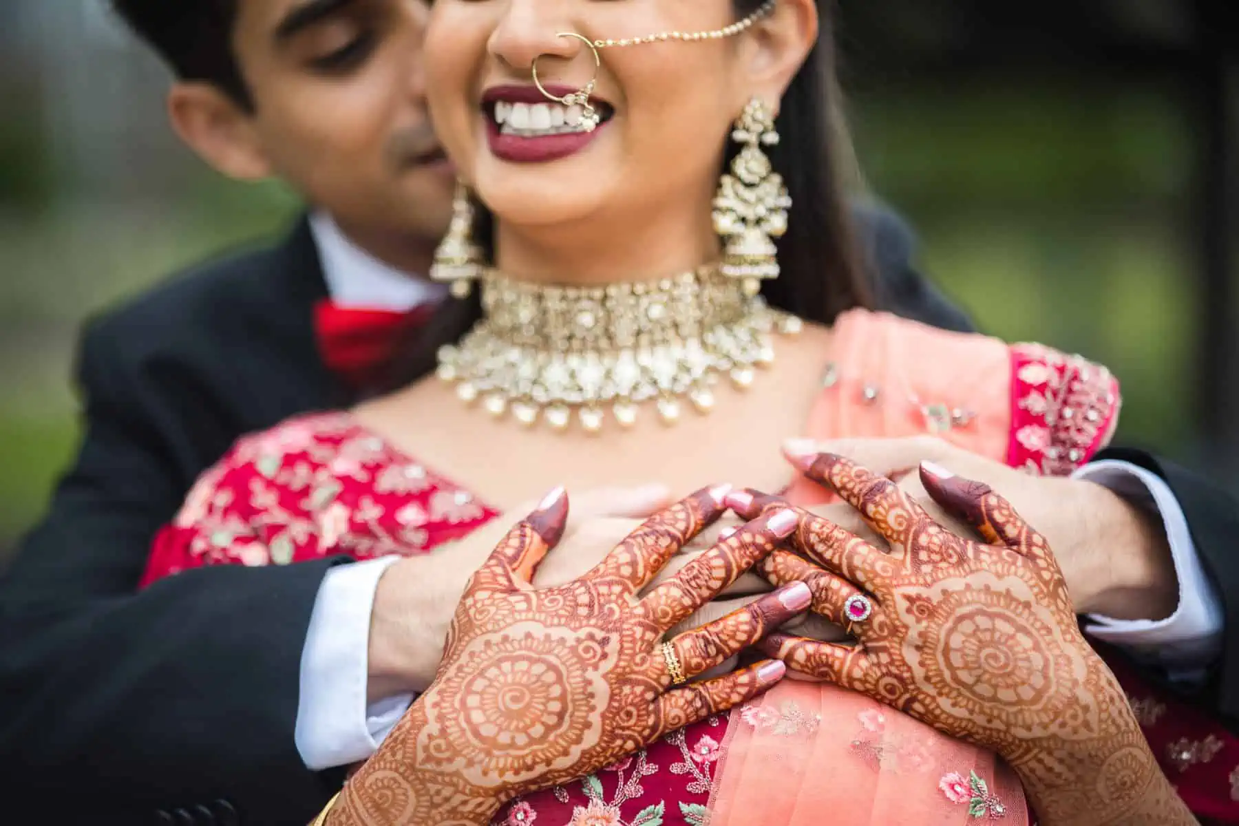 An indian bride and groom with henna on their hands.