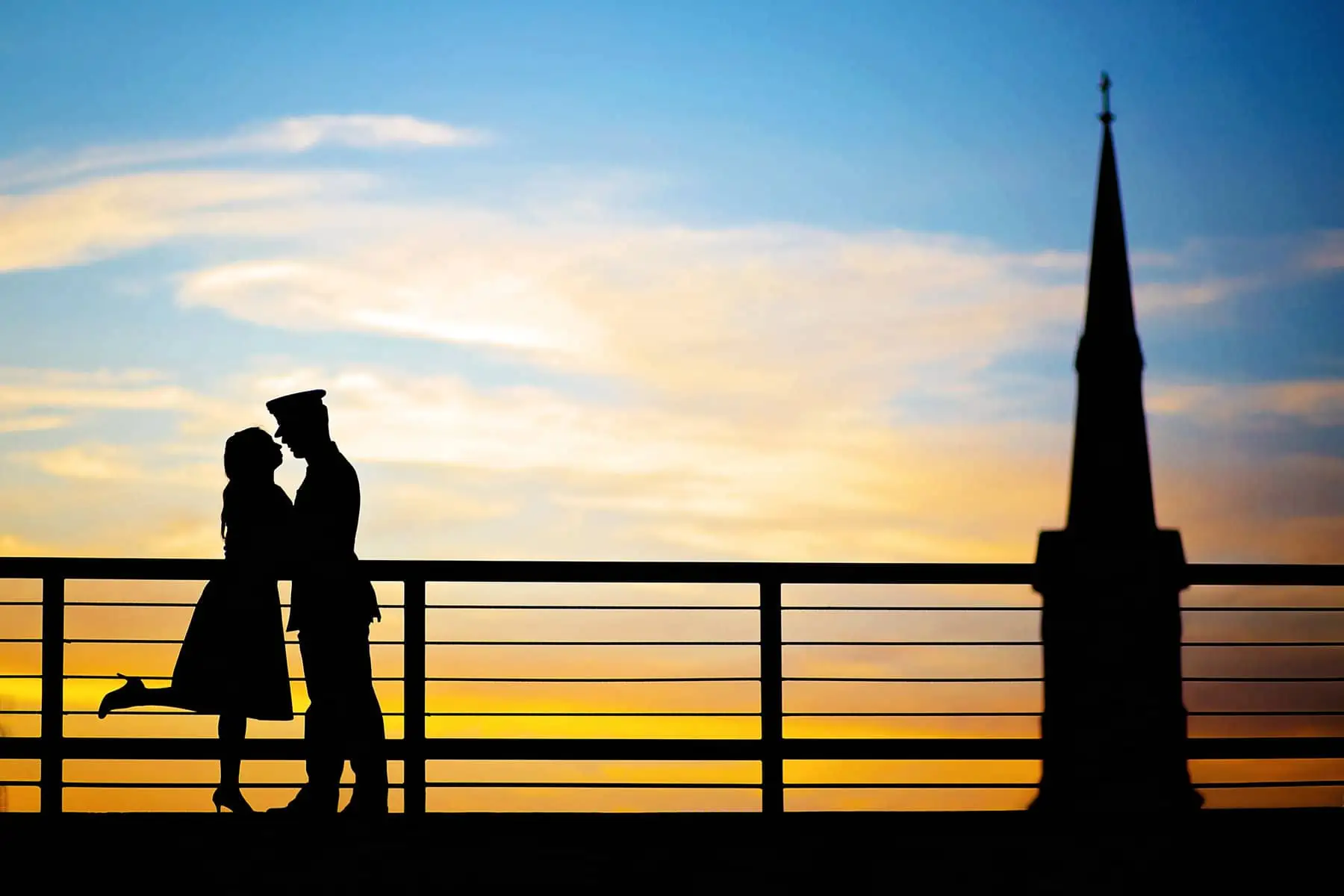 A silhouette of a couple kissing at sunset.