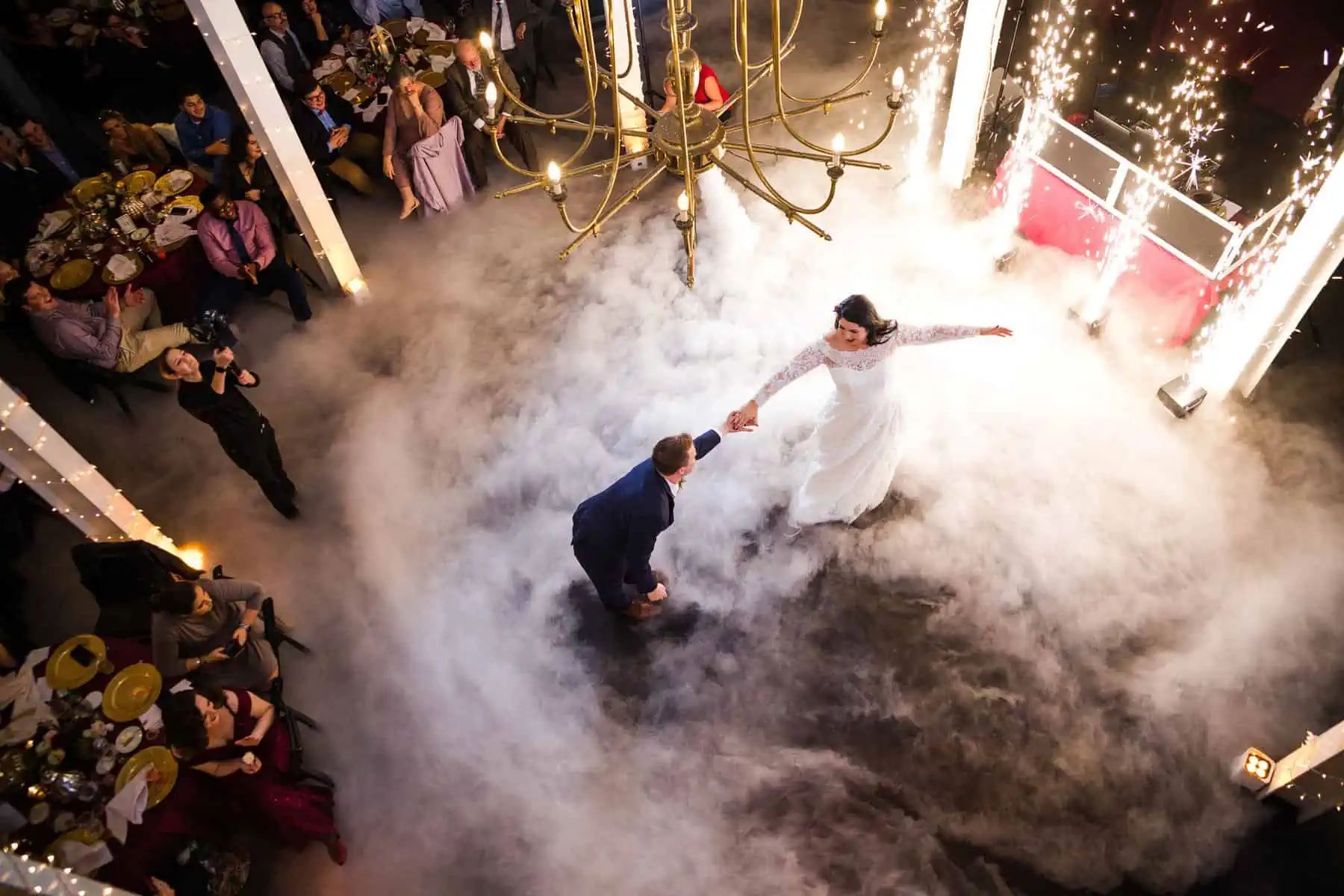 A bride and groom dancing in a smoke filled room.