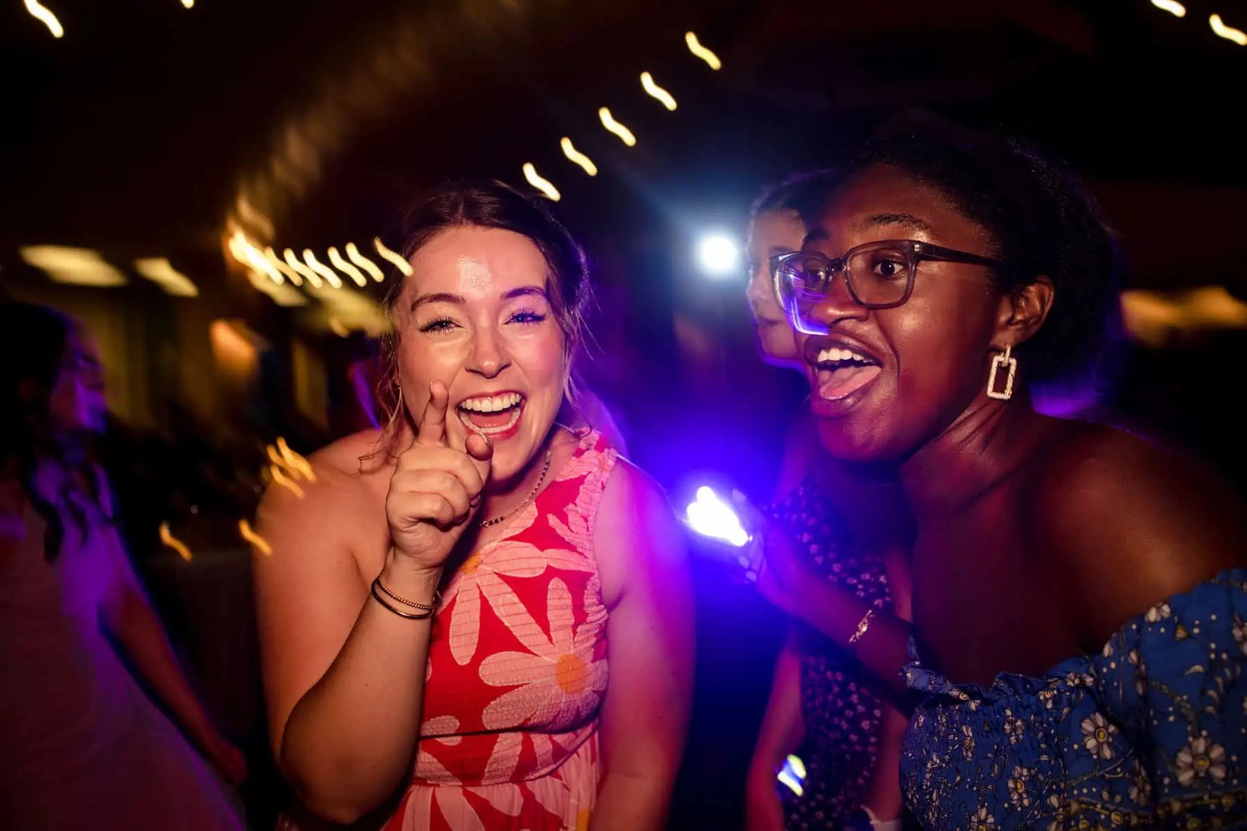 Two women dancing on the dance floor at a party.