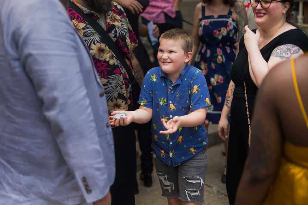 A Micro Wedding Gathering In Lexington, Ky With A Group Of People Standing Around A Young Boy.