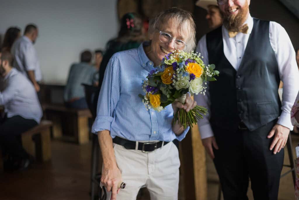 A Man Holding A Bouquet Of Flowers At A Micro Wedding In Lexington, Ky.