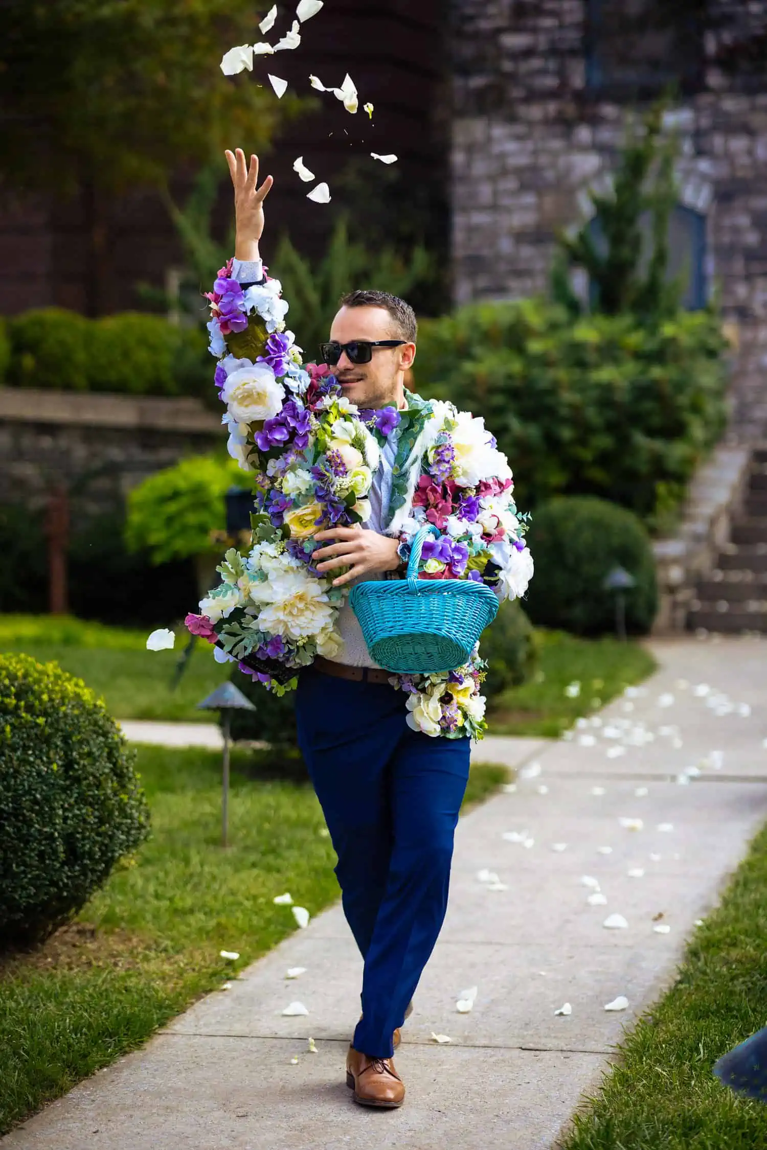 A man with a basket of flowers walking down a sidewalk.