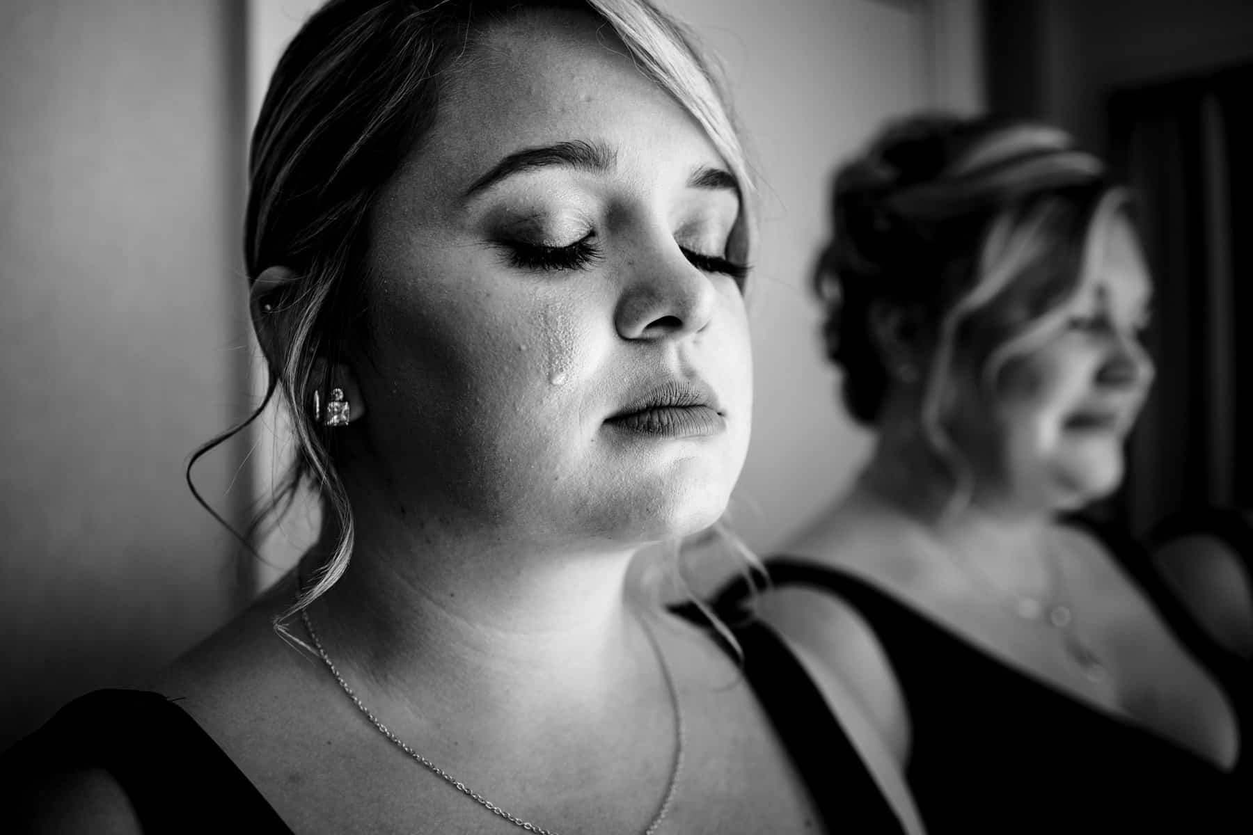 Two bridesmaids looking at each other in black and white.