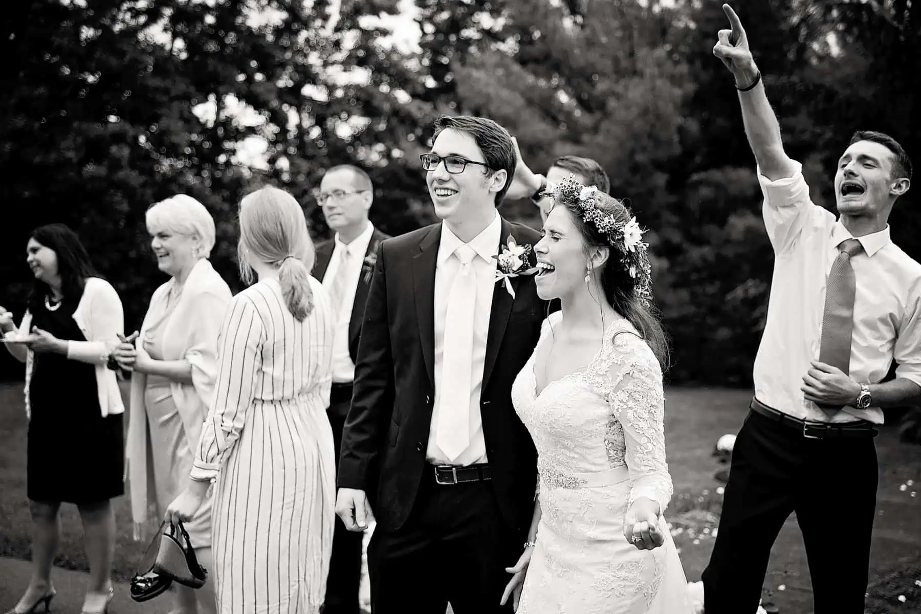 A black and white photo of a bride and groom celebrating their wedding.
