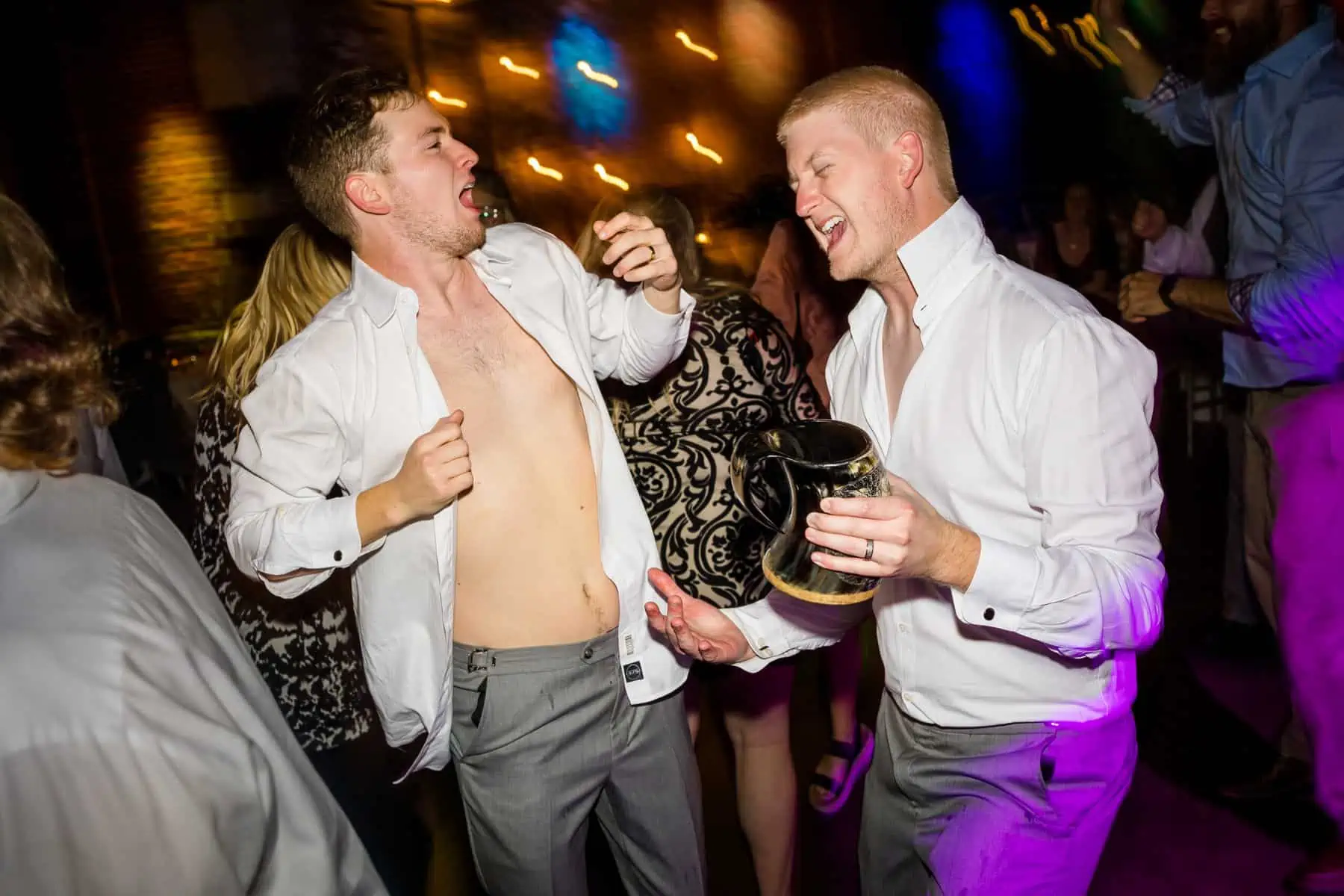 Two men dancing on the dance floor at a party.