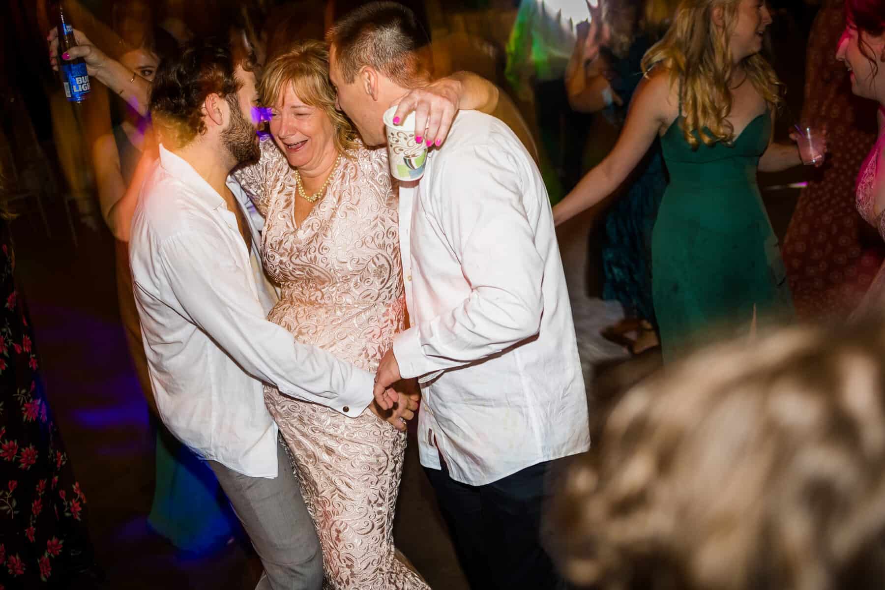 A group of people dancing on the dance floor at a wedding.
