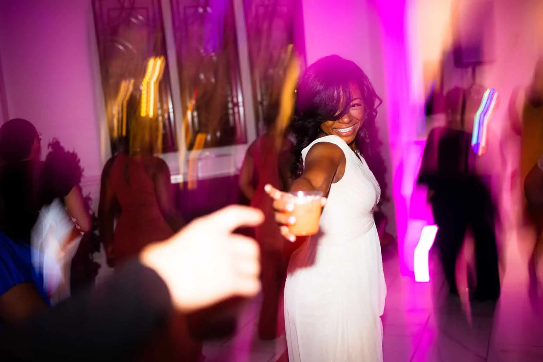A woman in a white dress dancing at a party.