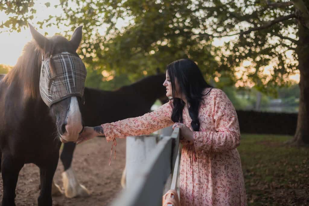 A Woman Engaged In Petting A Horse During A Sunset In Harrodsburg.