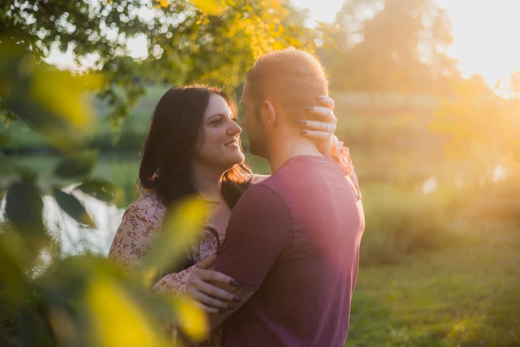 An Engaged Couple Embracing Under A Tree During Their Sunset Engagement Photos In Harrodsburg.