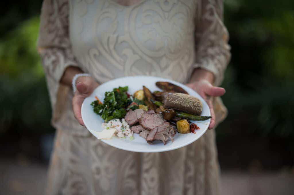 A woman holding a plate of food at a Kentucky event.