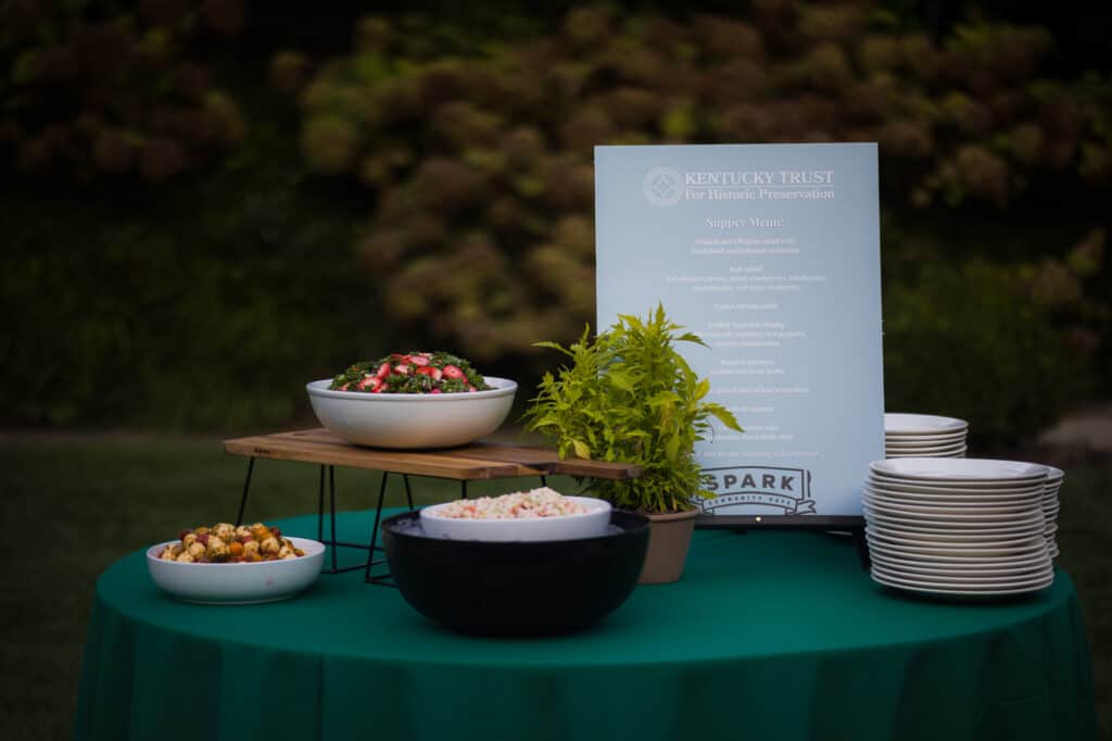 A table set up with bowls of food and a sign, captured beautifully by Kentucky event photography.