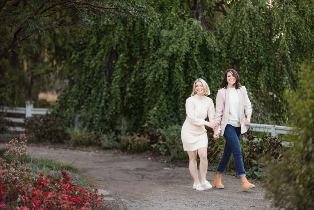 Two women, part of an LGBTQ+ family, walking down a path in a garden in Lexington.